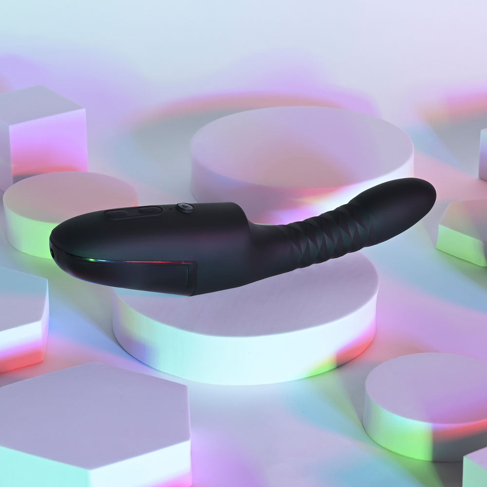 Playboy Pleasure OVERDRIVE - sleek design rechargeable thrusting vibrator against colorful geometric background.