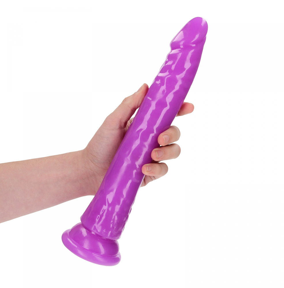 REALROCK 29 cm Slim Glow in the Dark Neon -  - Glow in Dark  29 cm (11'') Dong held in hand, showcasing its vibrant purple color.
