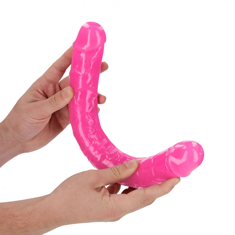 REALROCK 38 cm Double Dong Glow -  -  38 cm (15'') Double Dong in pink color, held by two hands, showcasing its design.