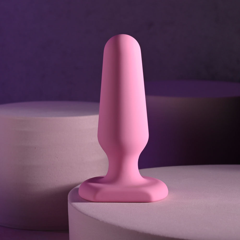 Selopa PETITE PLUG -  7.4 cm Butt Plug in pink silicone on modern display surface for intimate essentials.