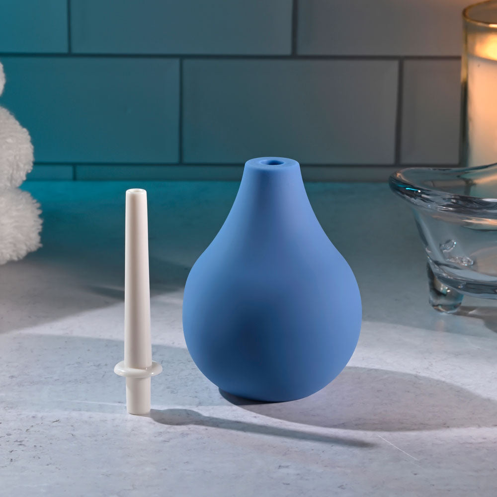 Selopa SQUEAKY CLEAN -  Unisex Douche next to nozzle on a countertop with candle in the background.