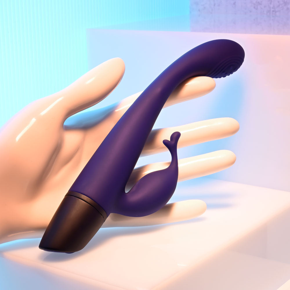 Selopa PLUM PASSION -  18.3 cm USB Rechargeable Rabbit Vibrator held in a hand against a colorful background.