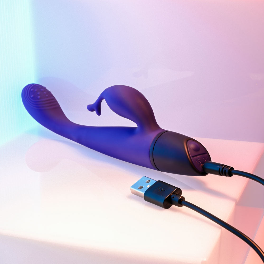 Selopa PLUM PASSION - 18.3 cm USB Rechargeable Rabbit Vibrator charging on a flat surface with a USB cable.