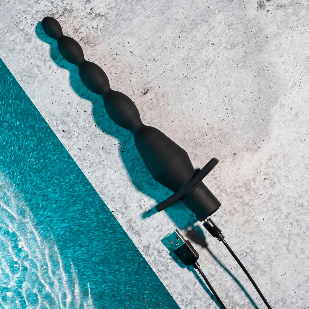 Selopa VIBRATING BUTT BEADS - 22 cm USB Rechargeable Vibrating Anal Beads on a textured surface.
