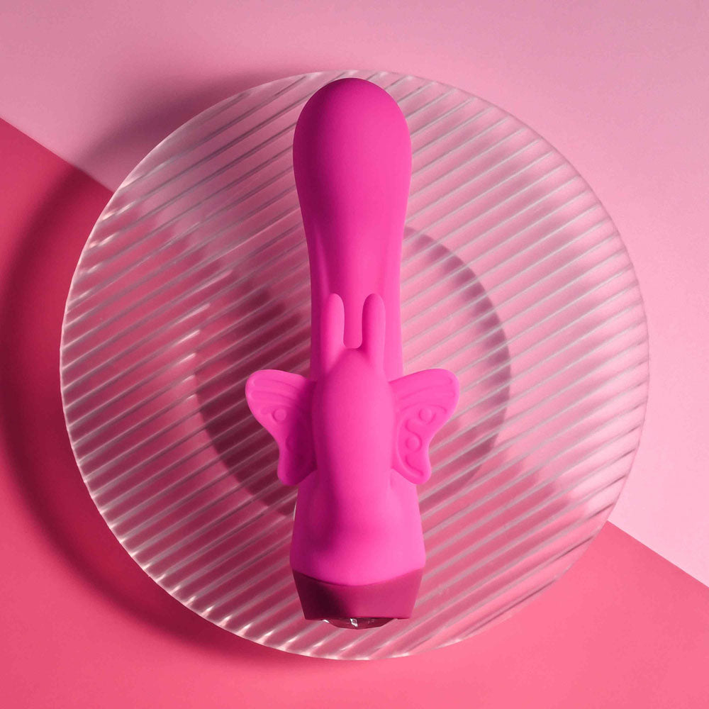 Selopa BUTTERFLY LOVE -  13.8 cm USB Rechargeable Butterfly Vibrator on a plate with a pink background.