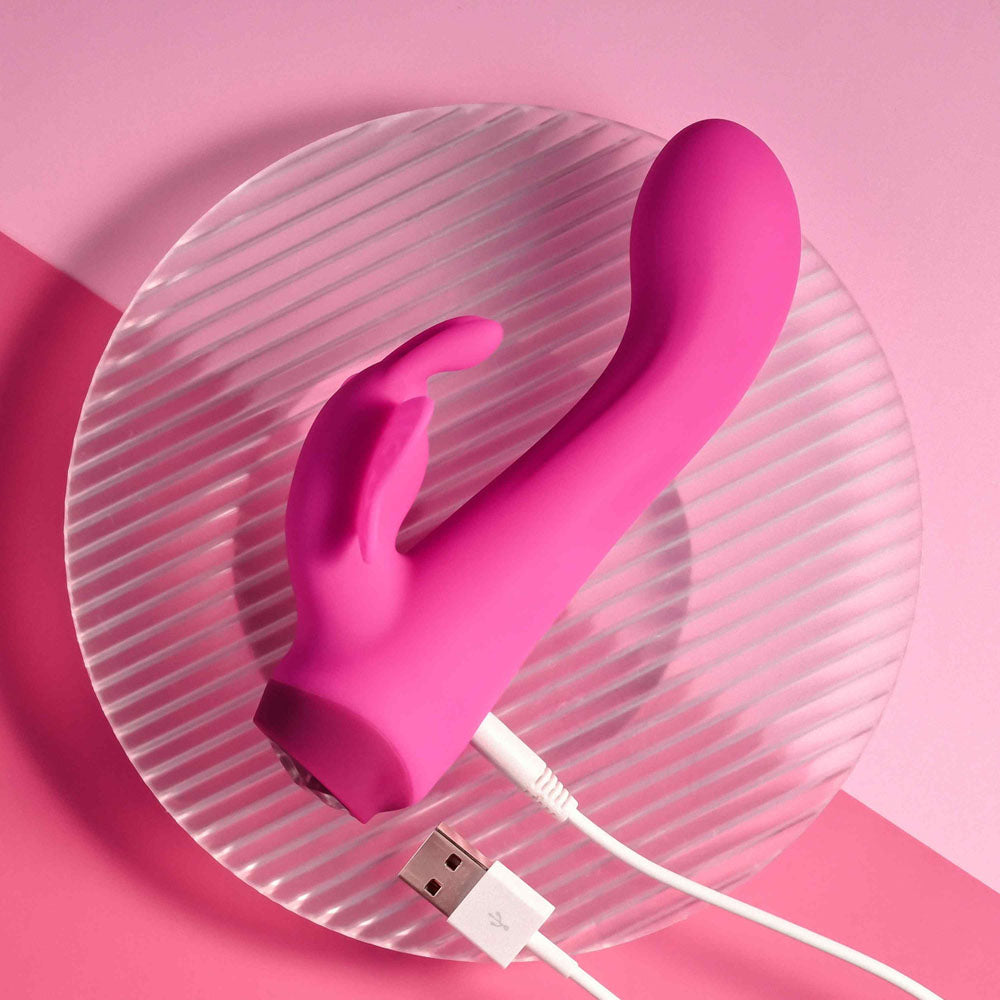 Selopa BUTTERFLY LOVE - 13.8 cm USB Rechargeable Butterfly Vibrator with pink silicone on a plate.