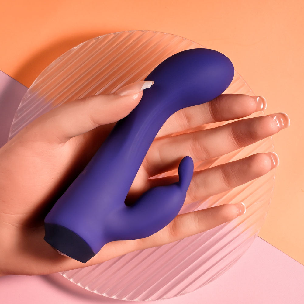 Selopa PLUM JOB - 13.5 cm USB Rechargeable Rabbit Vibrator held in hand on a circular plate, showcasing its design and color.