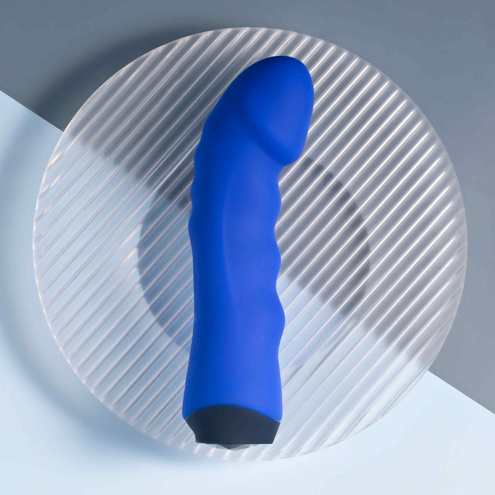 Selopa BANGER - 13.6 cm USB Rechargeable Vibrator on a clear plate with textured surface.