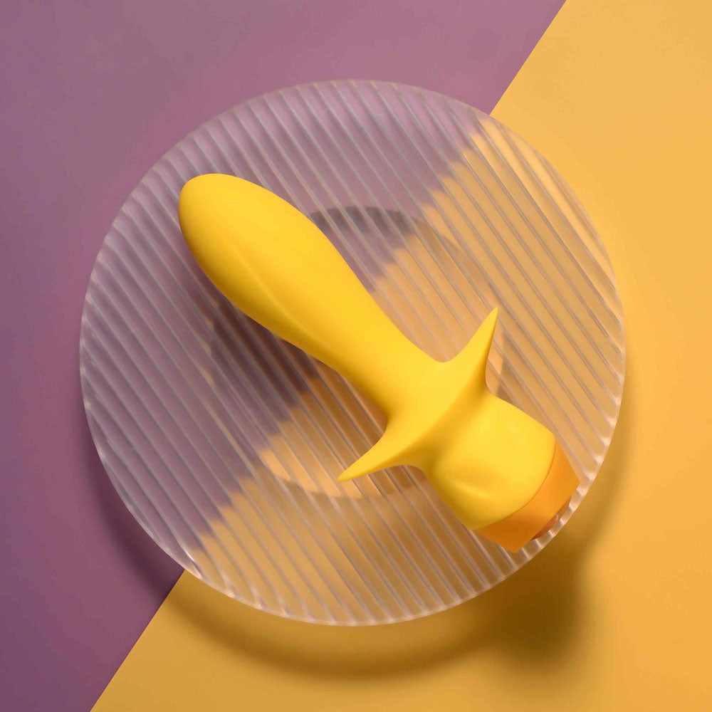 Selopa MELLOW  -  13.5 cm USB Rechargeable Vibrating Anal Plug on a striped plate in vibrant colors.