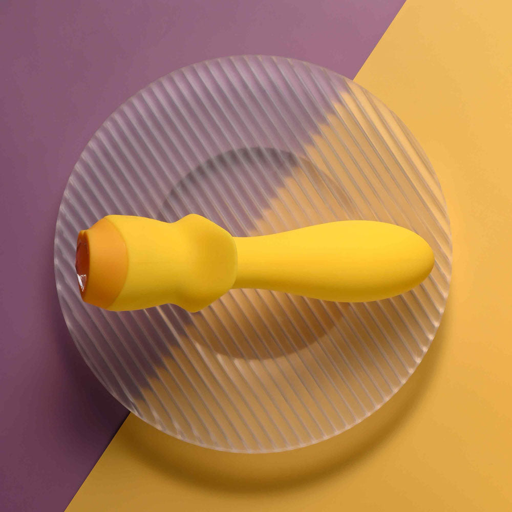 Selopa MELLOW  -  13.5 cm USB Rechargeable Vibrating Anal Plug on a textured plate in vibrant colors.