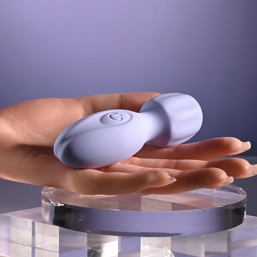 Selopa LIL' WAND - 11 cm USB Rechargeable Massage Wand held in a hand against a soft purple background.