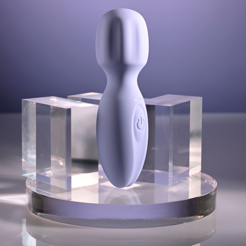 Selopa LIL' WAND -  11 cm USB Rechargeable Massage Wand displayed on a clear pedestal with a purple backdrop.