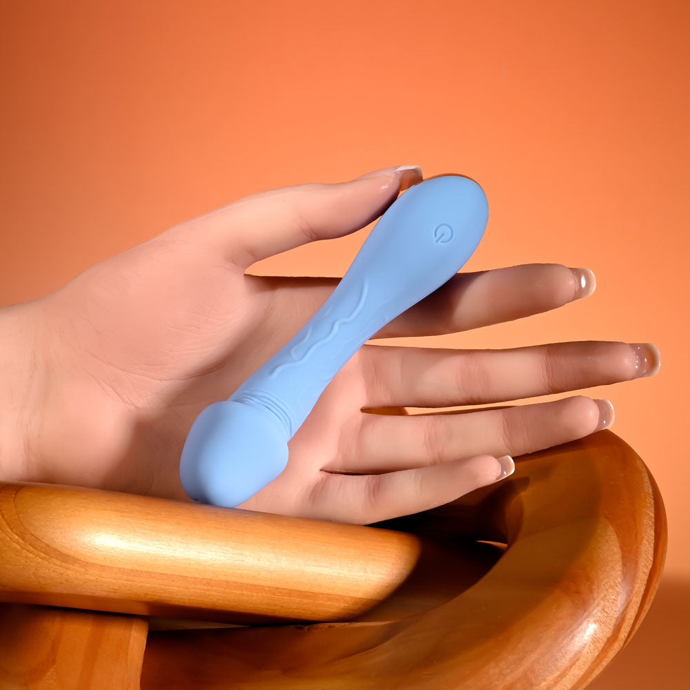 Selopa DAINTY DICK - Baby 11.9 cm USB Rechargeable Mini Vibrator held in hand against a warm background.