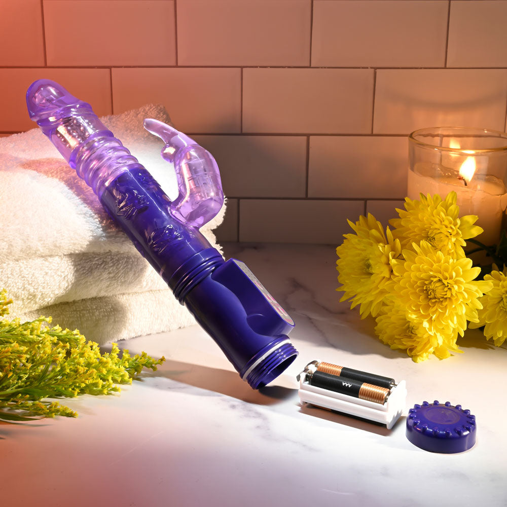 Selopa BUNNY THRUSTER - 24.8 cm Thrusting Rabbit Vibrator with purple design, battery compartment, and surrounded by flowers.