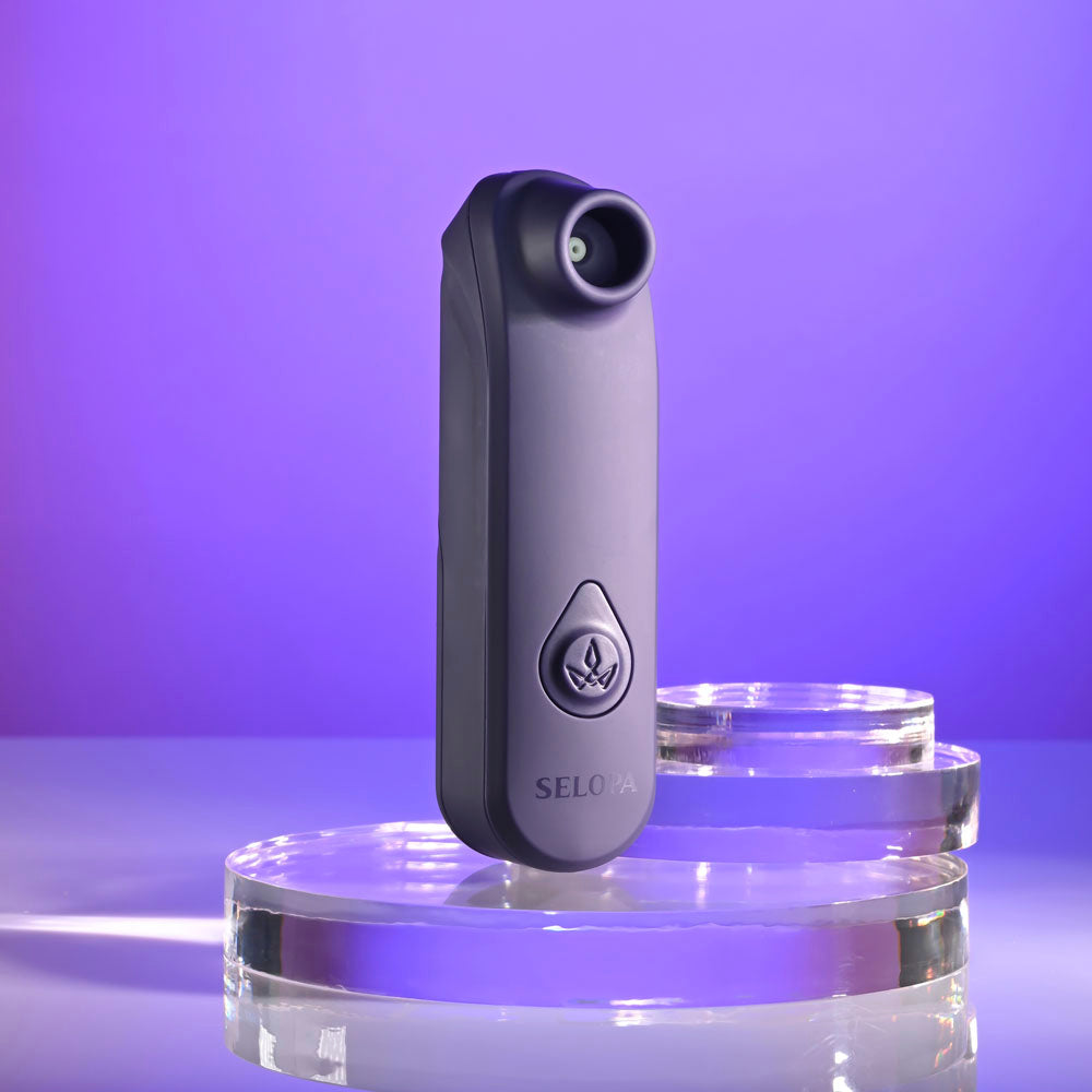 Selopa SURE THING -  Vibrating & Sucking Stimulator on a glass surface with a purple background.