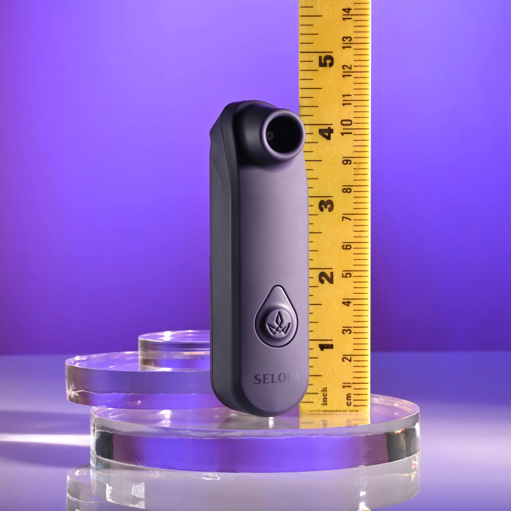 Selopa SURE THING -  Vibrating & Sucking Stimulator next to a ruler for size reference on a purple background.