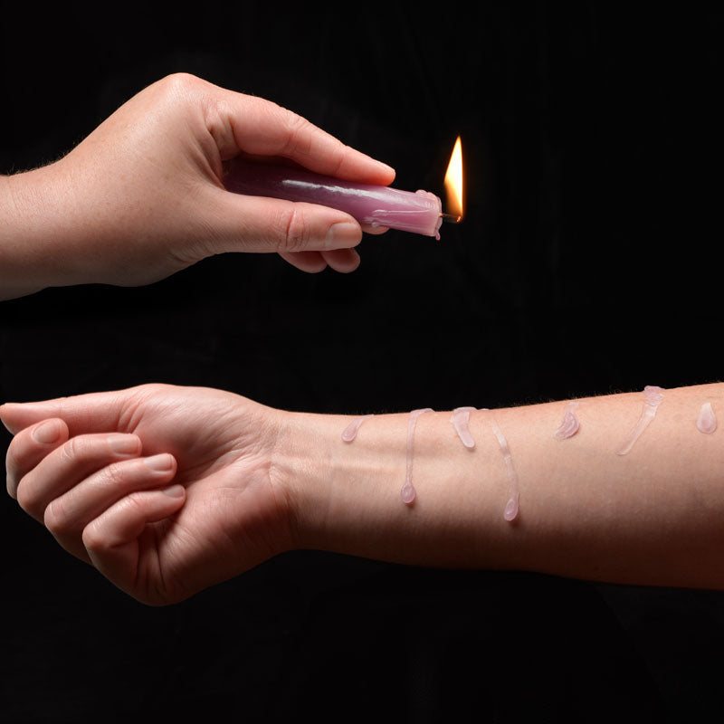 LaCire Drip Pillar Candles - Violet - Violet Drip Candles - Set of 3 pouring warm wax on arm.