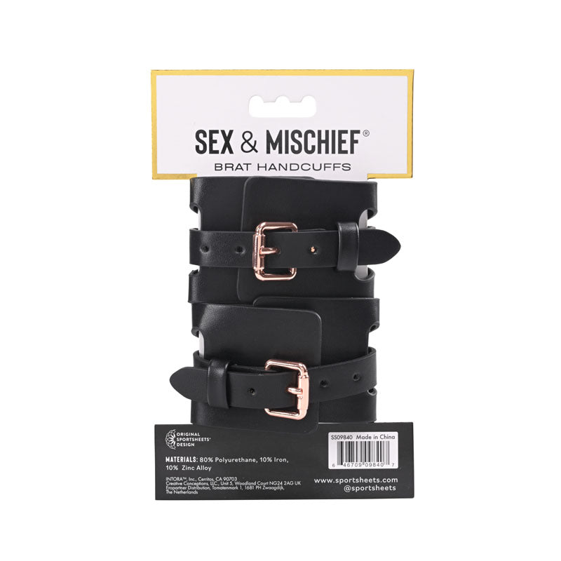 Sex & Mischief Brat Handcuffs - /Rose Gold Restraints displayed on a packaging with luxurious black straps and elegant rose gold buckle.