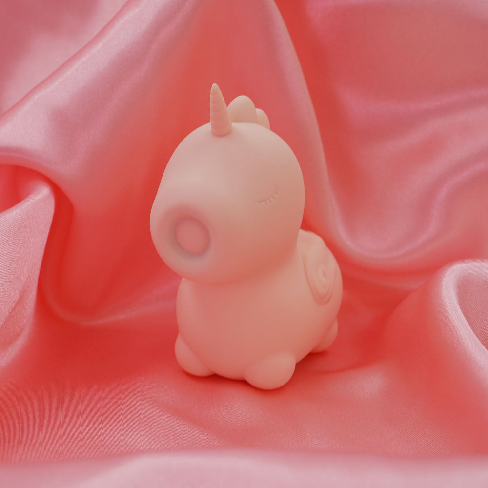 Unihorn - Heart Throb - Coral USB Rechargeable Flicking Stimulator on soft pink fabric, perfect intimate essentials for her.