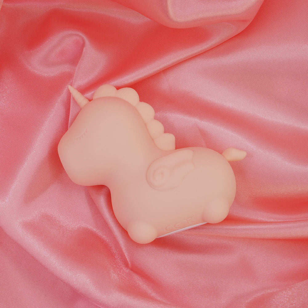 Unihorn - Heart Throb - Coral USB Rechargeable Flicking Stimulator on pink satin fabric for intimate essentials for her.
