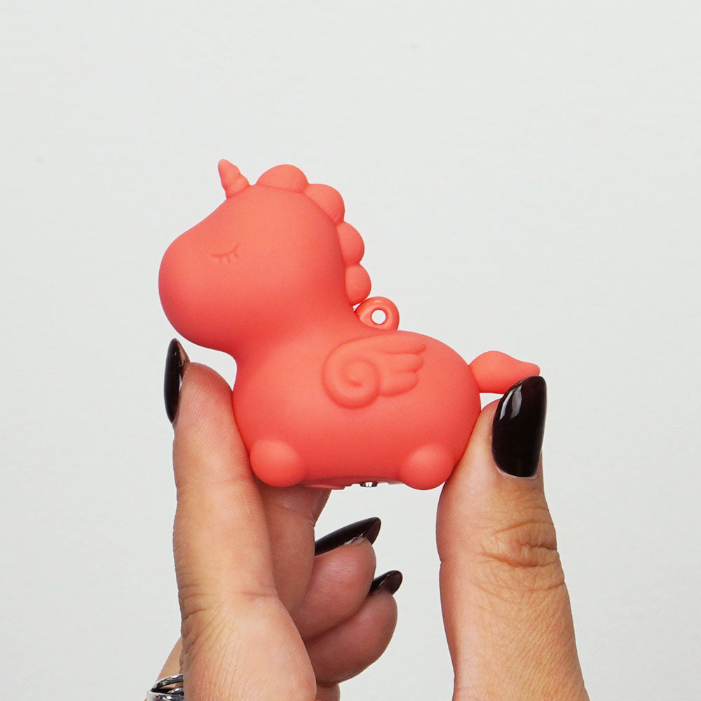 Unihorn Mini - Peachy Pony - Peach USB Rechargeable Stimulator in hand, showcasing its cute design and vibrant color.