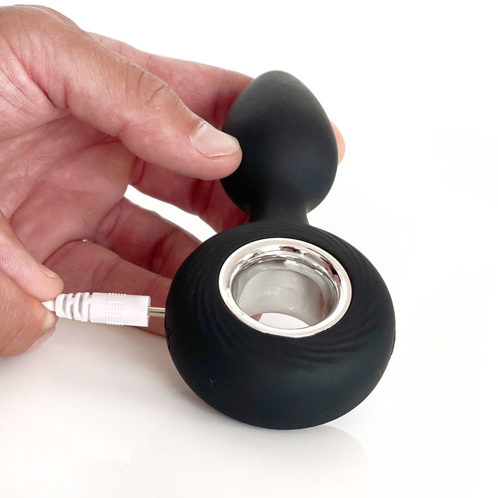 Hand holding the VERS Rechargeable Silicone Plug Vibe - 12.5 cm USB Rechargeable Vibrating Butt Plug during charging.