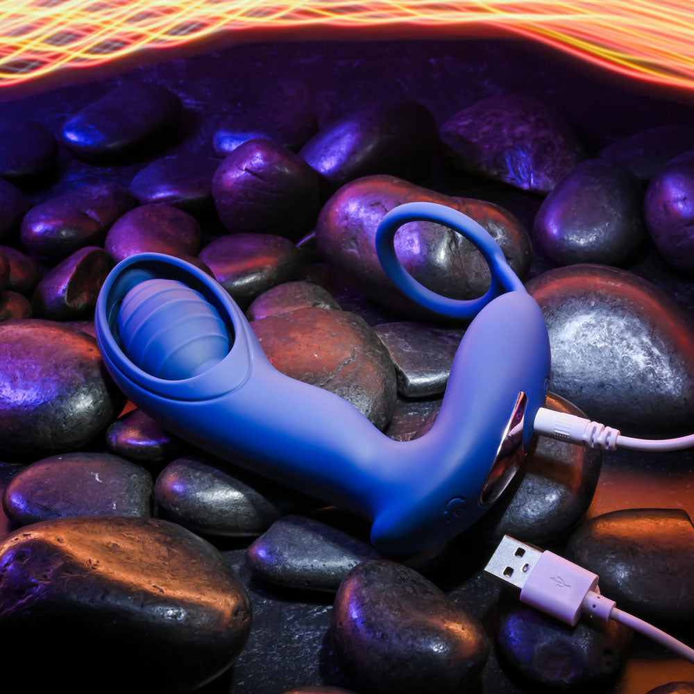 Zero Tolerance EXTRA MILE -  USB Rechargeable Vibrating Prostate Massager on black stones with USB charging cable.