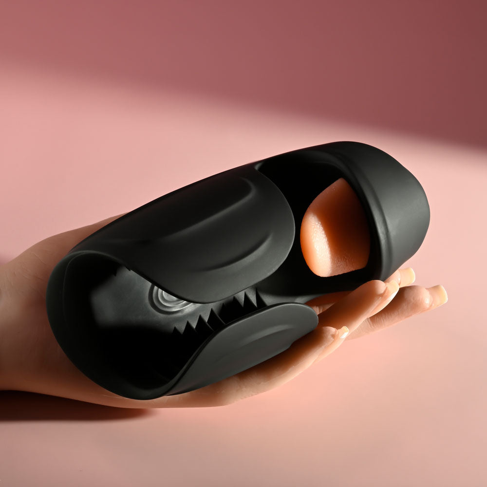 Zero Tolerance LICK THE TIP - USB Rechargeable Vibrating & Flicking Masturbator in hand against pink background.