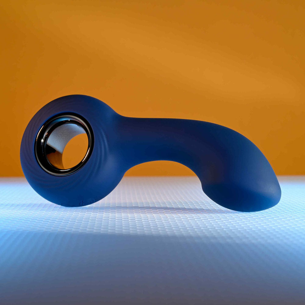 Zero Tolerance THE REACH -  13.8 cm USB Rechargeable Vibrating Anal Plug on a blue surface with a warm background.