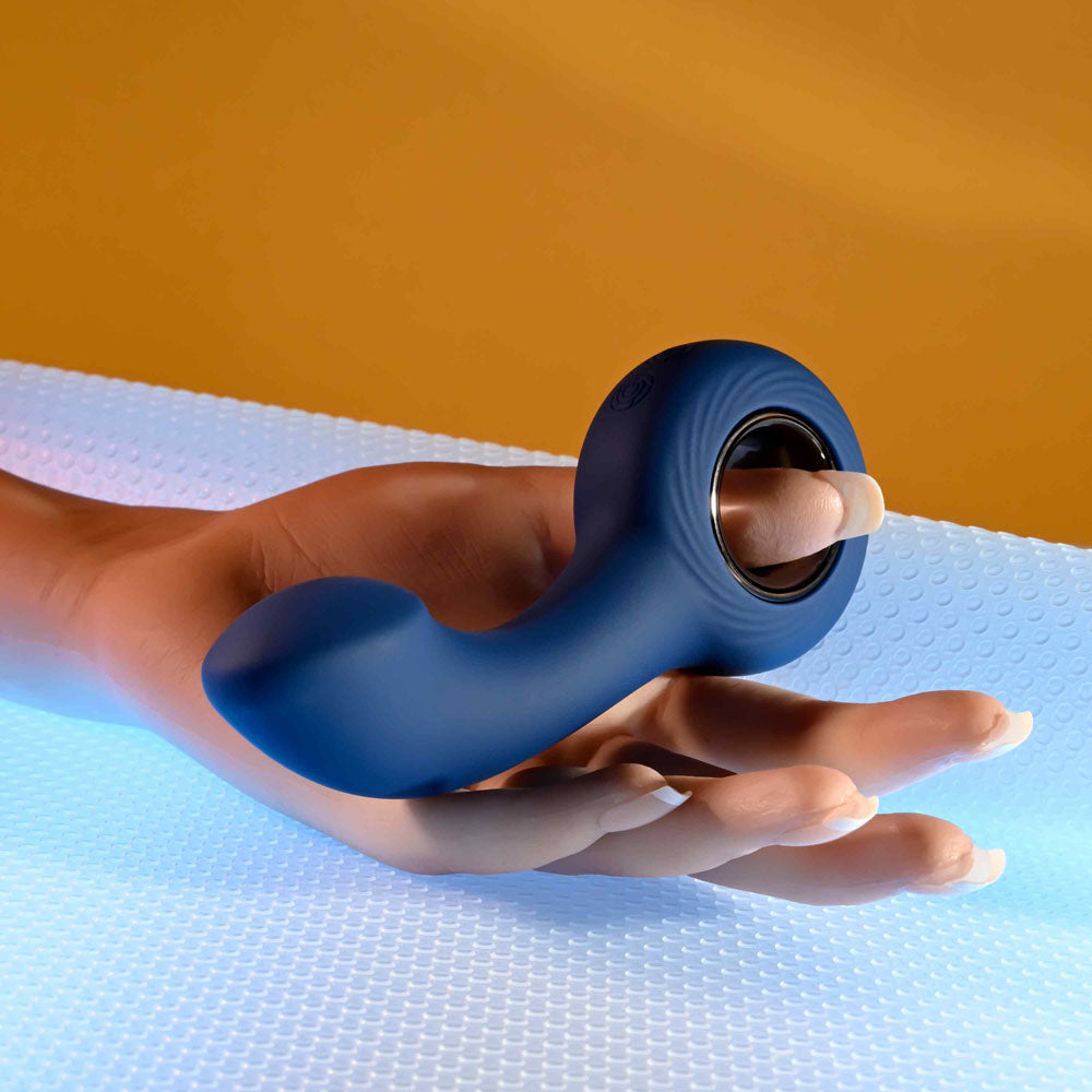 Zero Tolerance THE REACH -  13.8 cm USB Rechargeable Vibrating Anal Plug held in a hand on a colorful surface.