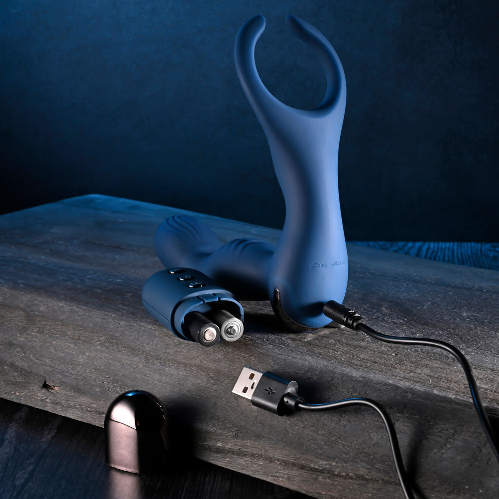 Zero Tolerance BY ALL MEANS -  13.4 cm USB Rechargeable Prostate Massager with Cock Ring on a wooden surface.